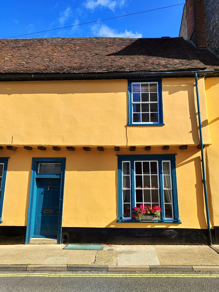 Old orange house with blue framed windows.